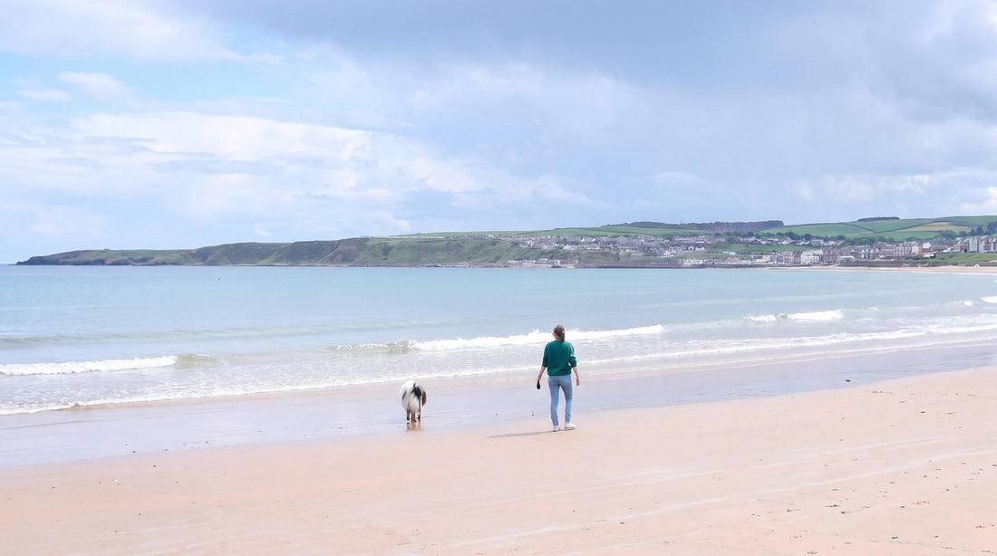 Hundemama am Strand mit Hund im Urlaub